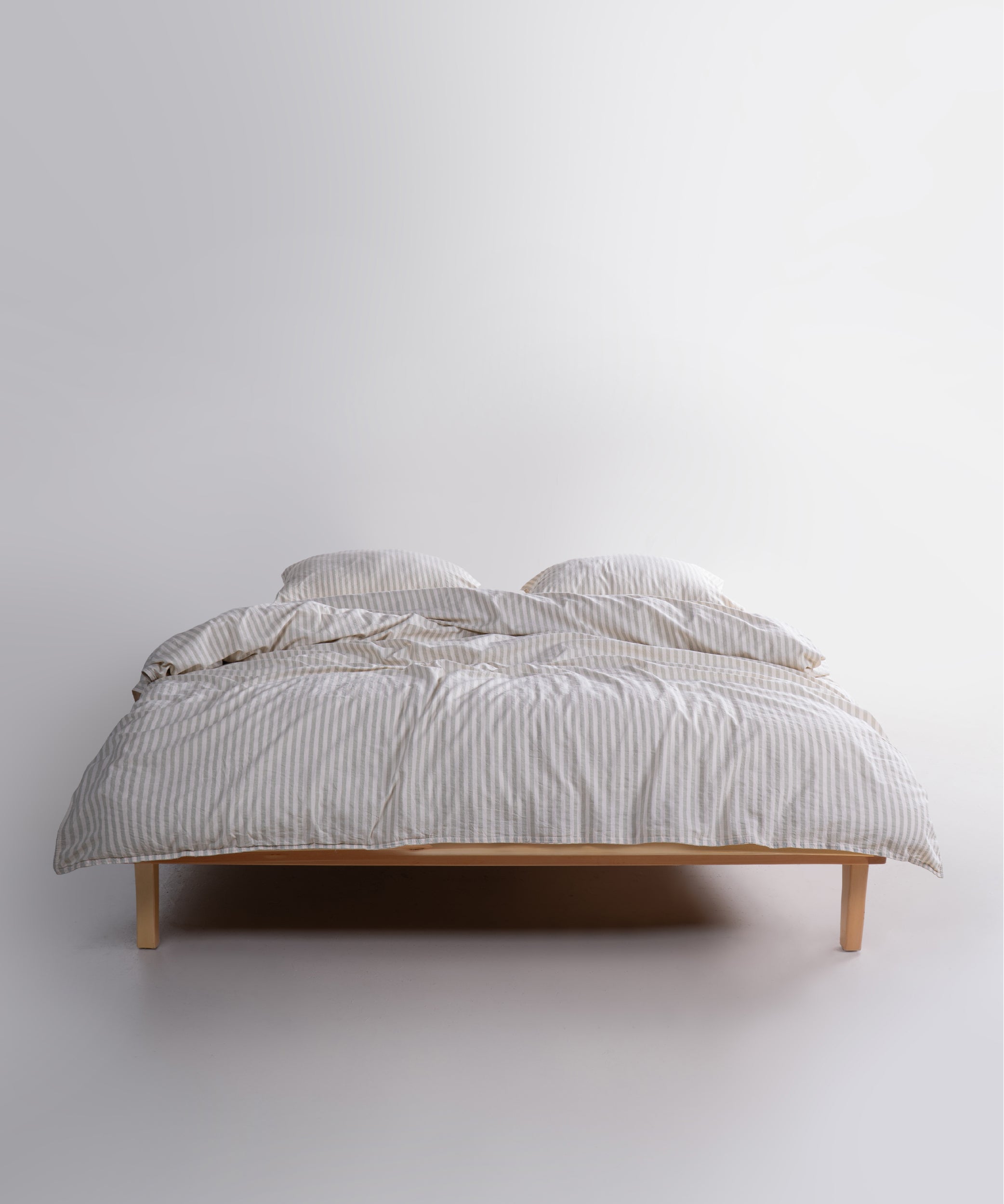 Natural green striped cotton duvet cover set styled on a UK bedroom bed