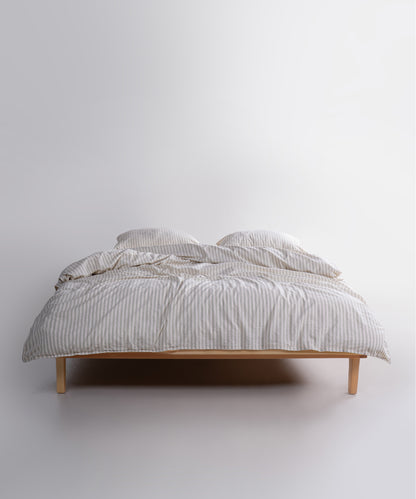Natural green striped cotton duvet cover set styled on a UK bedroom bed