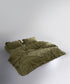 Olive green stonewashed cotton duvet cover set styled on a double bed
