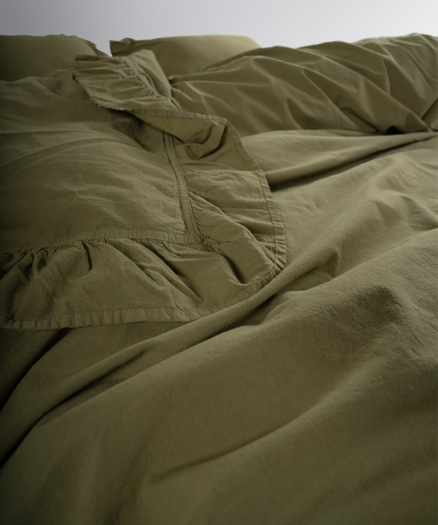 Ruffled edge detail on olive green stonewashed cotton duvet cover