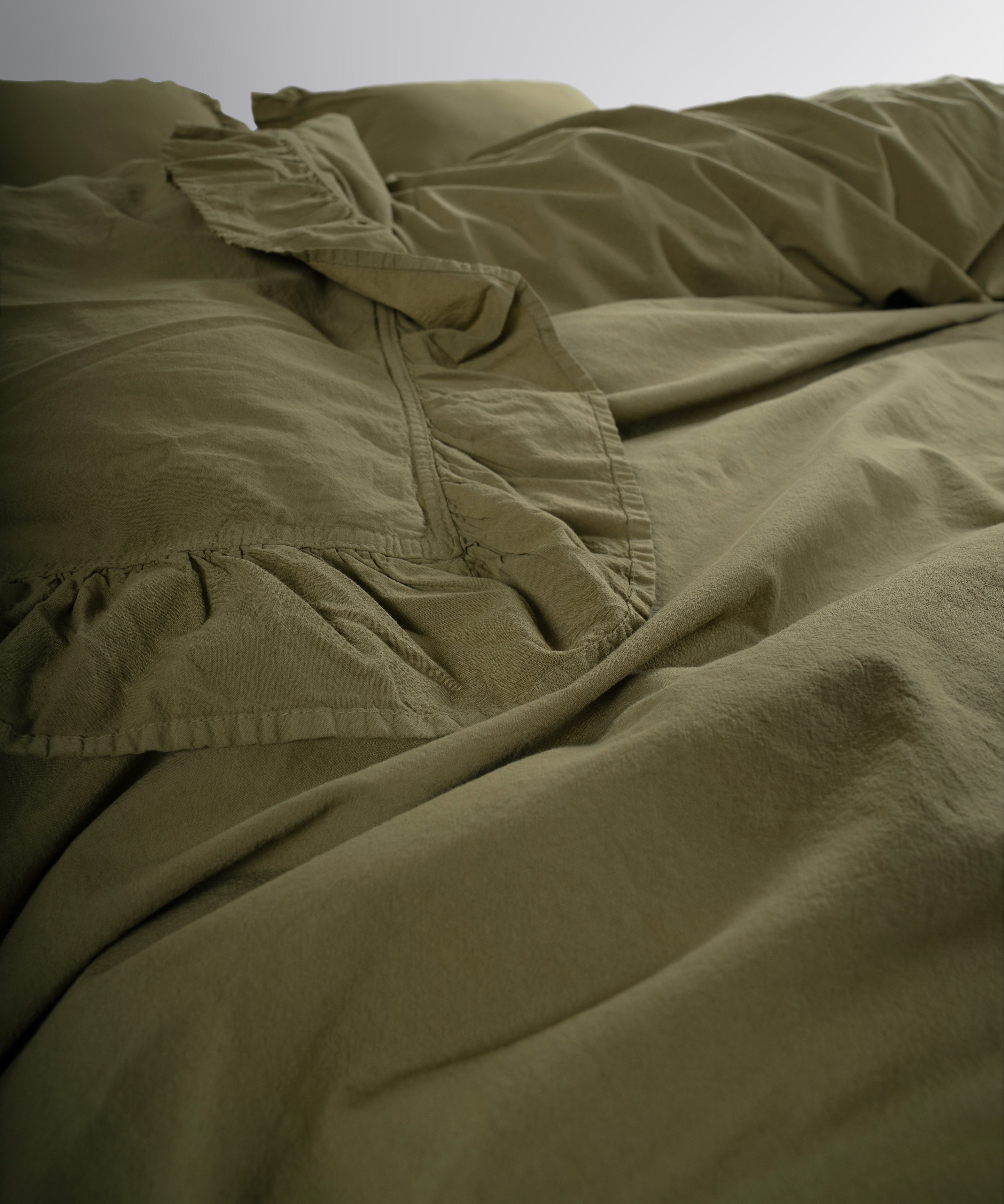 Ruffled edge detail on olive green stonewashed cotton duvet cover