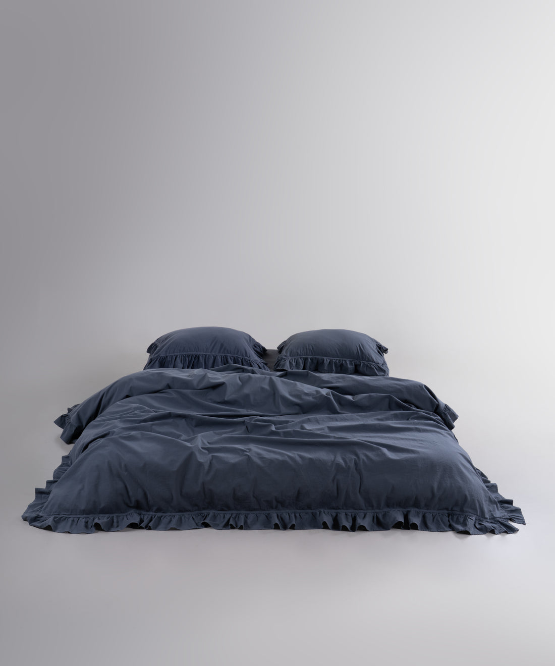 Stonewashed 100% cotton duvet cover set in Castle Rock anthracite with elegant ruffle detailing
