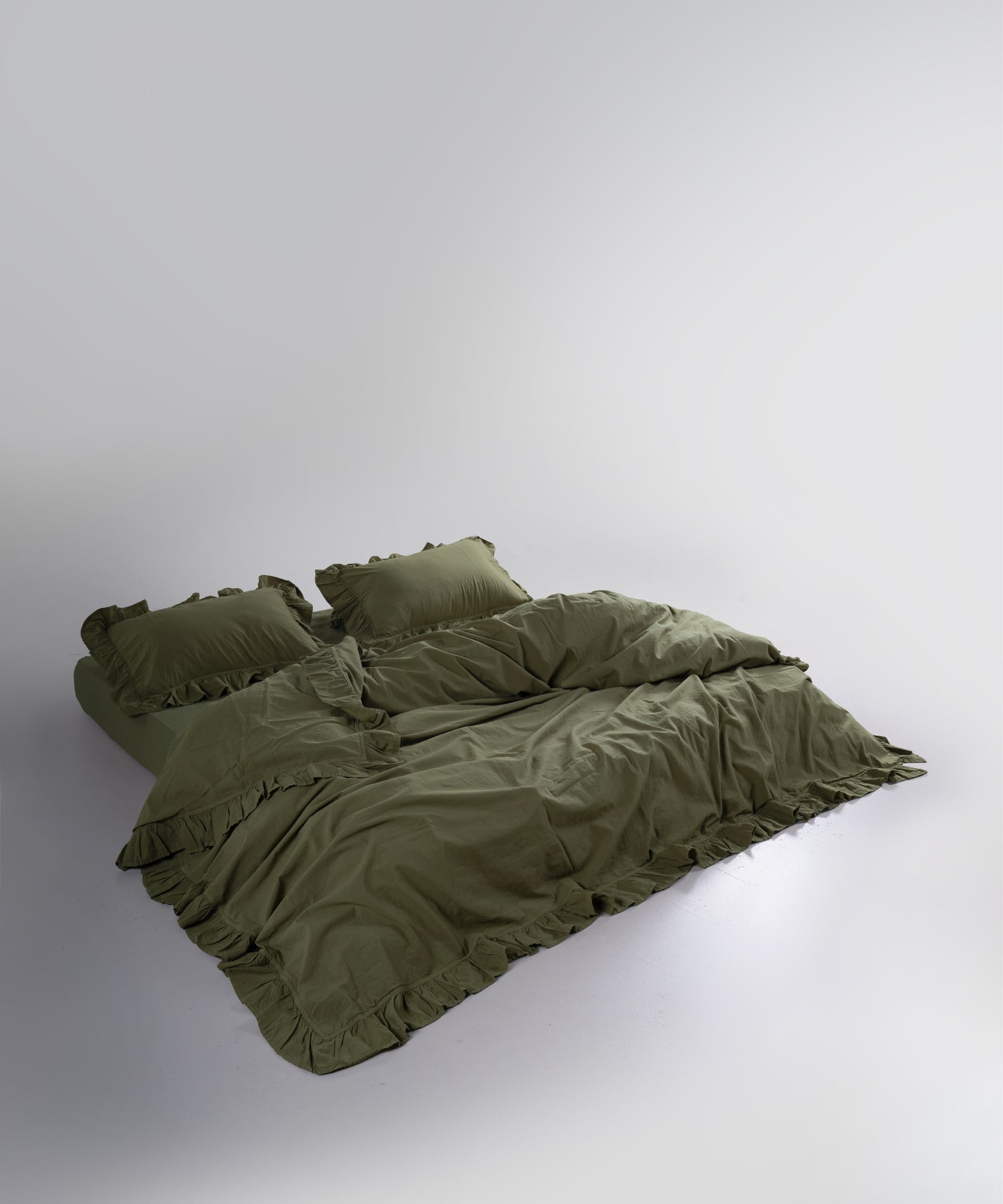 Side view of stonewashed cotton duvet cover set showing relaxed texture and ruffle trim
