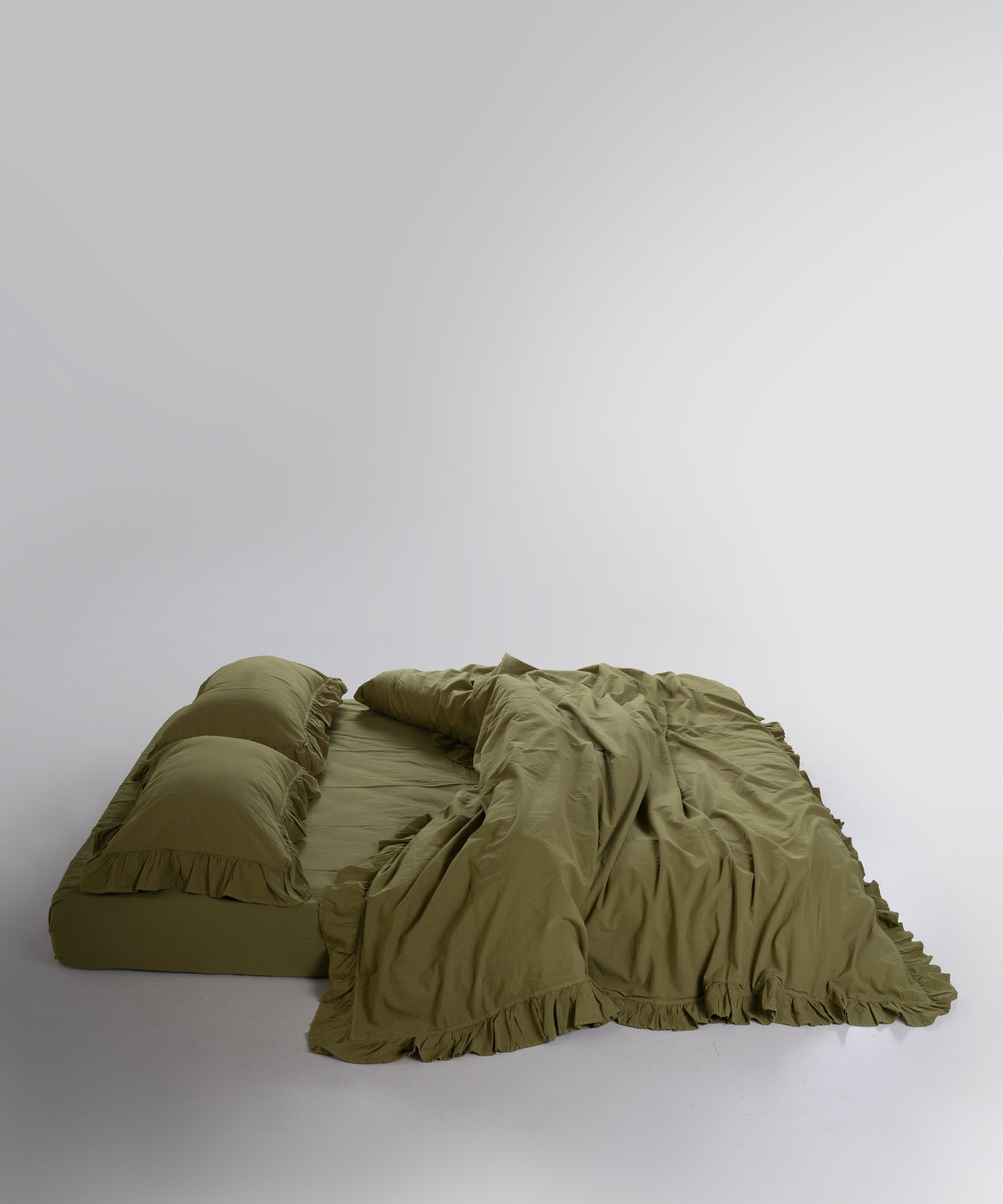 Close-up of stonewashed 100% cotton fabric texture in olive green
