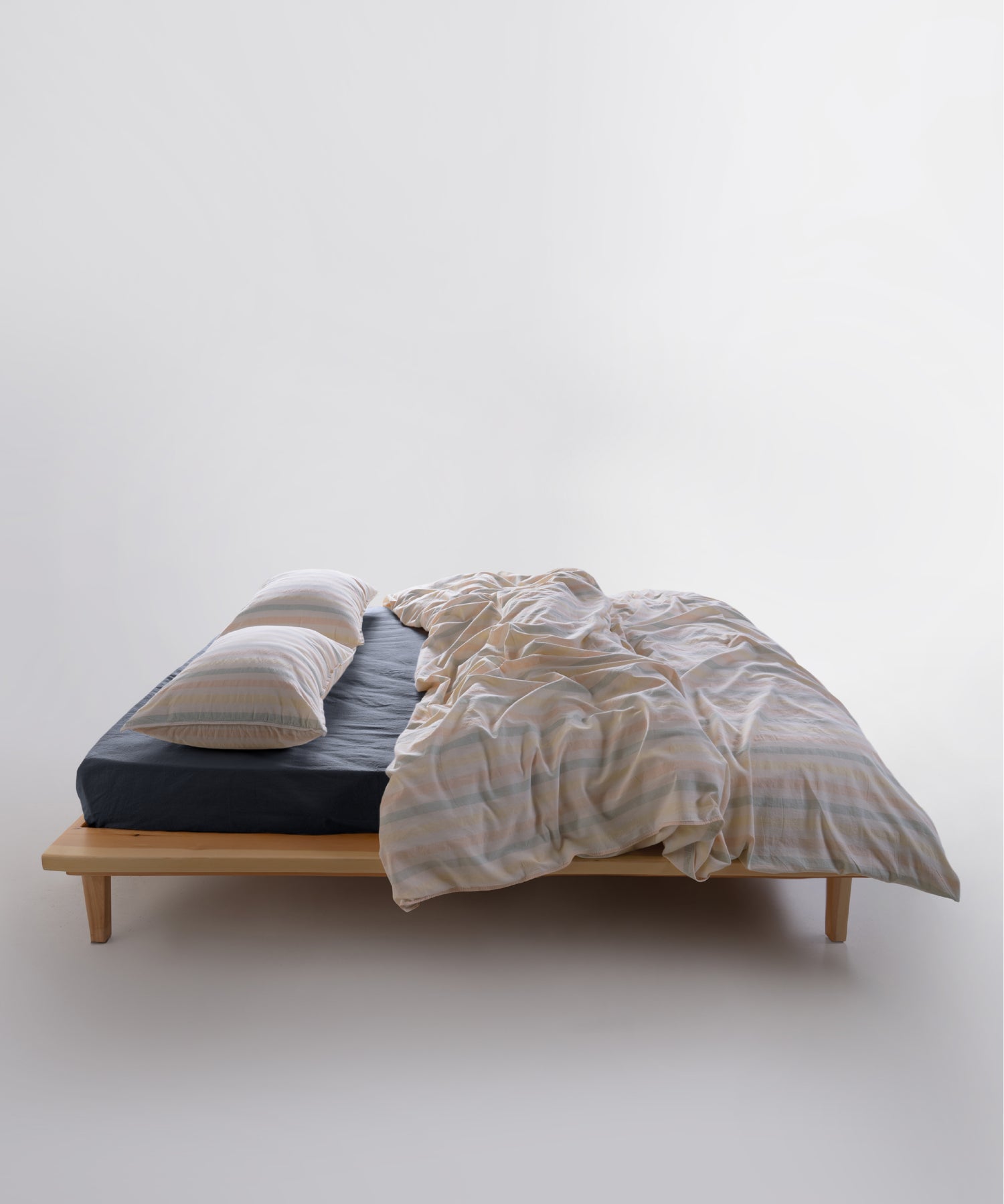 Striped garment washed cotton duvet cover set styled on a bed with a relaxed, natural bedroom look