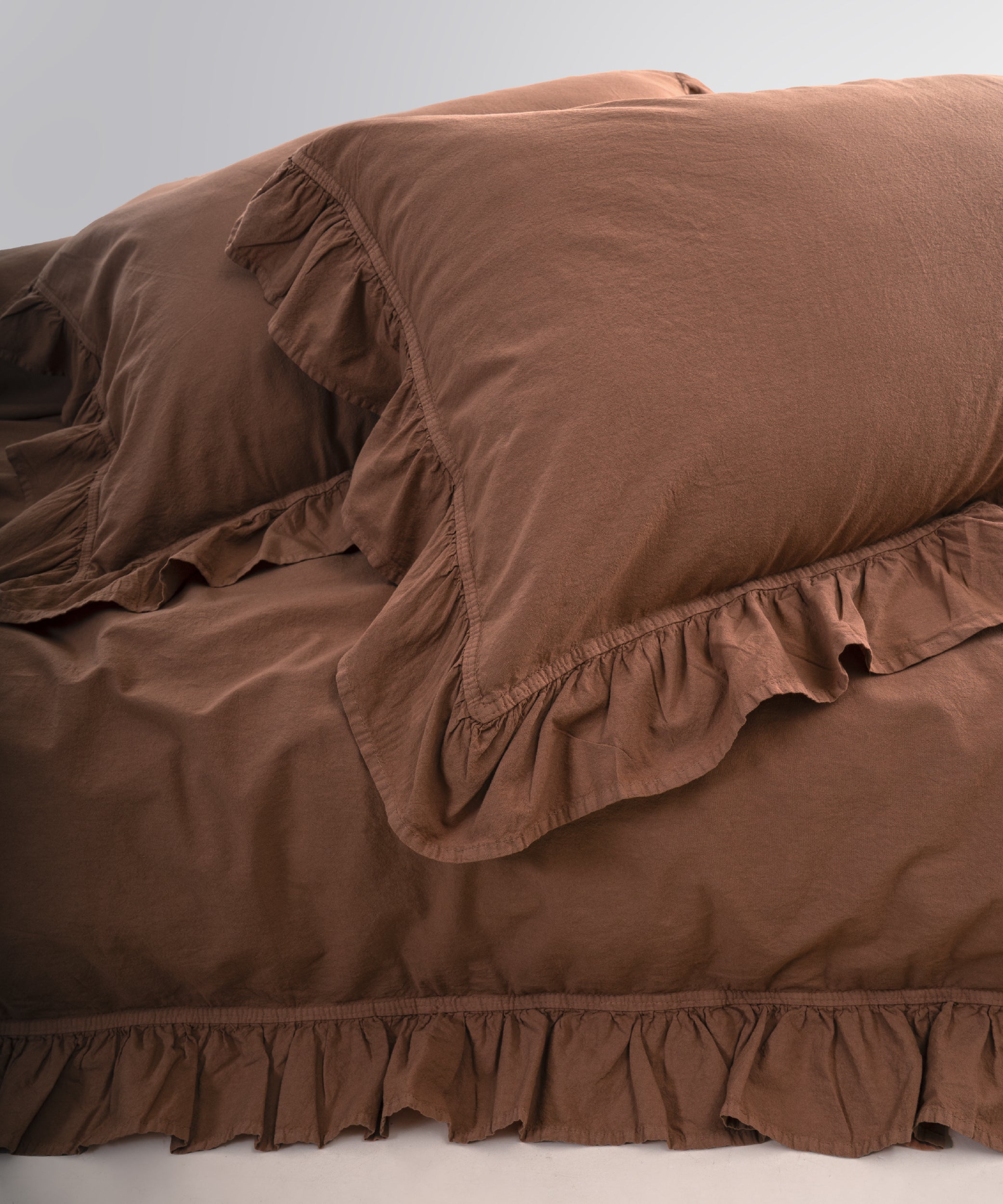 Stonewashed cotton pillowcases with ruffle edges in wood smoke shade, soft and breathable fabric
